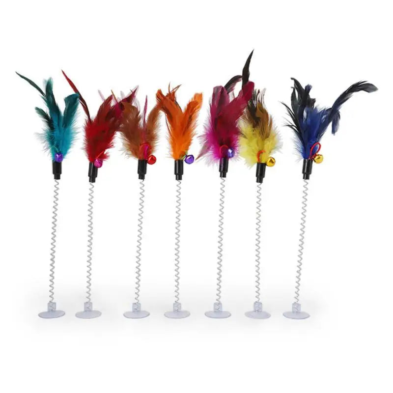 Jouet interactif isolant pour chat avec six plumes colorées sur un support blanc, petite cloche cloche