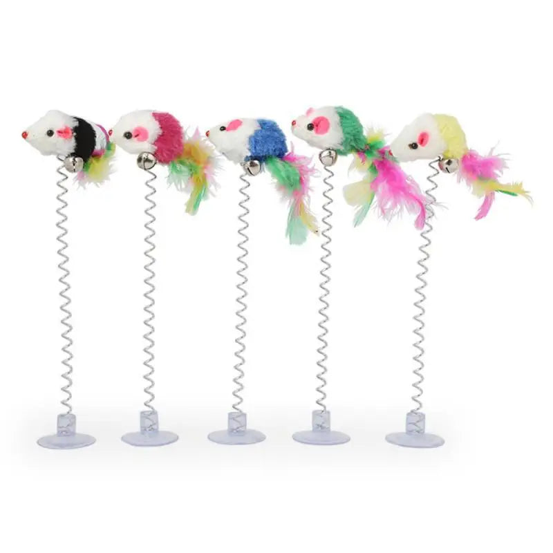 Trois plumes colorées d’un petit jouet interactif isolé pour chat avec une petite clochette sur fond blanc
