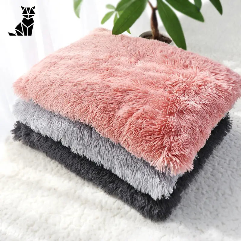 Lit douillet pour chien avec un coussin en peluche rose et gris sur un tapis blanc